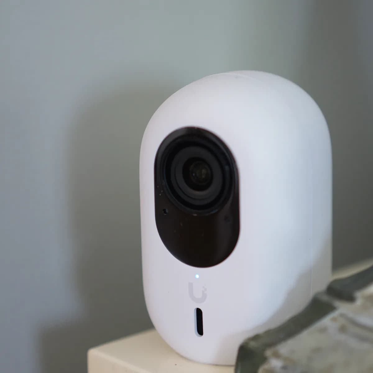 A G6 Instant on a shelf indoors, lens and status LED facing the room, USB-C port on the underside.
